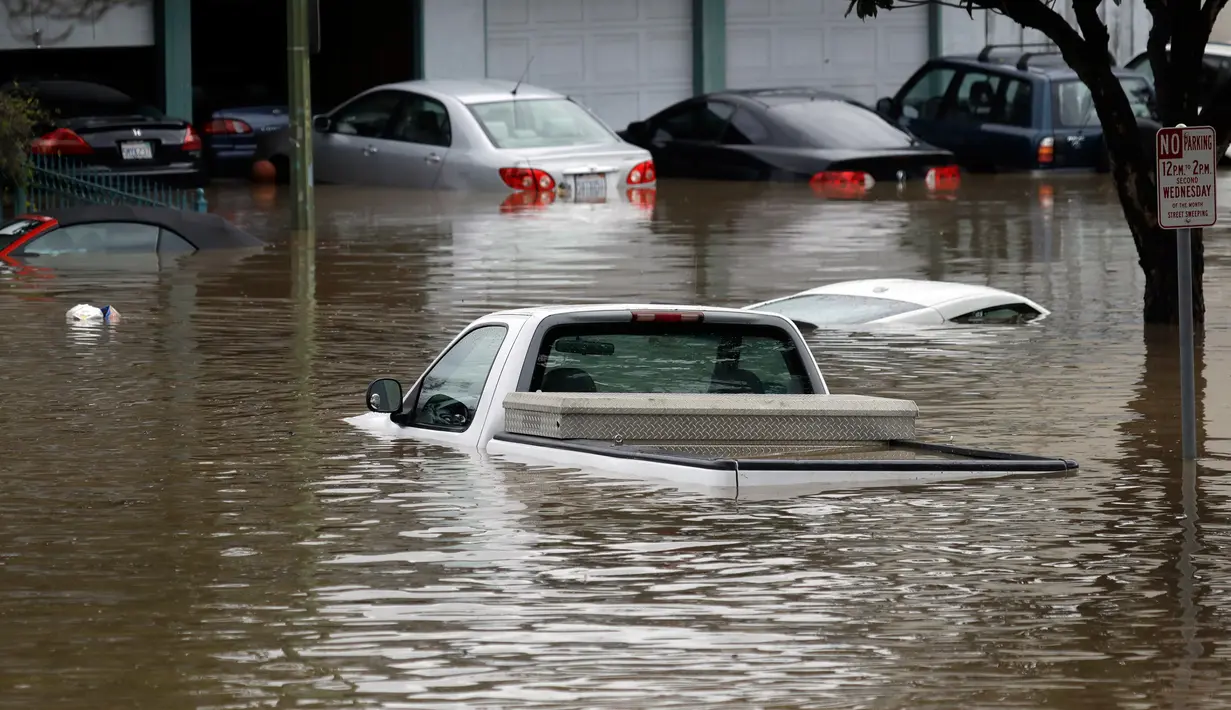 Sejumlah mobil terendam banjir di San Jose, California, Selasa (21/2). Banjir terjadi akibat meluapnya Sungai Coyote Creek yang tidak mampu menampung debit air setelah hujan lebat. (AP Photo/Marcio Jose Sanchez)
