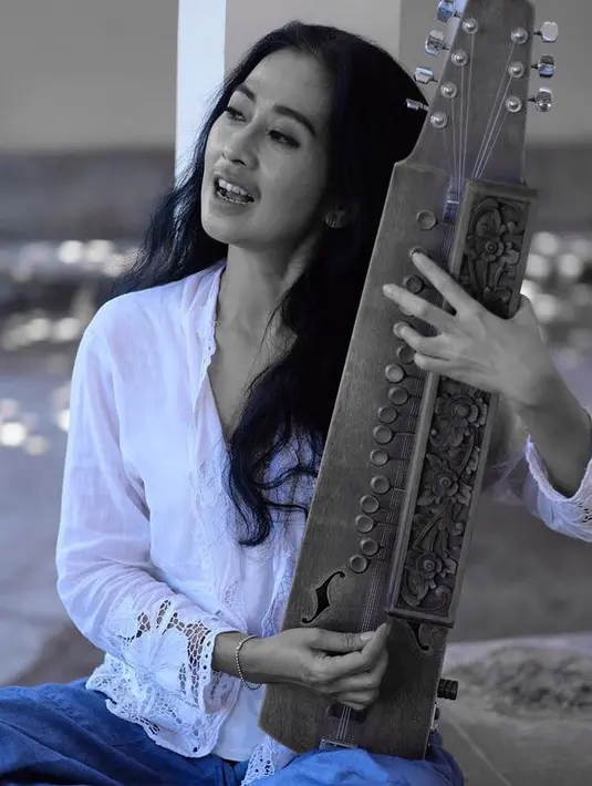 Aktris Ayu Laksmi berpose sambil memegang alat musik. Dalam dunia musik, Ayu Laksmi membentuk grup musik bernama Svara Semesta yang sering tampil di Bali. (instagram/ayulaksmibali)
