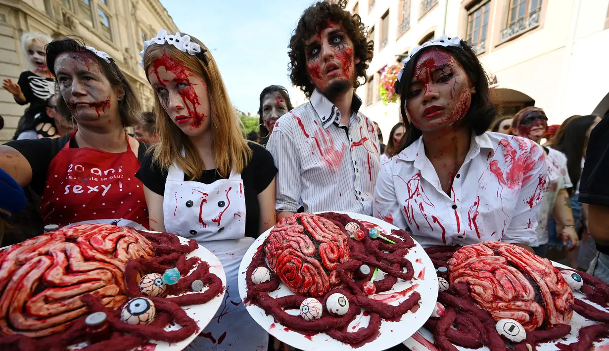 Warga memakai kostum dan berdandan menyerupai zombie saat mengambil bagian dalam acara Zombie Walk di kota Strasbourg, Prancis, 14 September 2019. Acara yang digelar dalam rangka Festival Film Fantasi Eropa ke-12 ini berlangsung dari  14 hingga 23 September. (FREDERICK FLORIN / AFP)