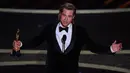 Brad Pitt memberikan pidato saat menerima piala Oscar di atas panggung ajang Academy Awards ke-92 yang digelar di Dolby Theatre, Los Angeles, Minggu (9/2/2020). Brad Pitt menyabet penghargaan sebagai Aktor Pendukung Terbaik untuk aktingnya di film Once Upon a Time in Hollywood. (Mark RALSTON / AFP)