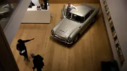 Seorang staf berpose dengan Aston Martin DB5 yang digunakan dalam film James Bond GoldenEye tahun 1995 rumah lelang Bonham, London, Selasa (19/6). Mobil itu diperkirakan harganya mencapai 1,6 juta pound sterling atau sekitar Rp30 miliar. (AP/Matt Dunham)