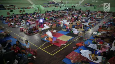 Sejumlah pengungsi Gunung Agung berisitirahat di lokasi pengungsian GOR Swecapura, Klungkung, Bali, Minggu (3/12). Pengungsi Gunung Agung yang berada di Kabupaten Klungkung terus bertambah dengan total 9.304 jiwa. (Liputan6.com/Immanuel Antonius)