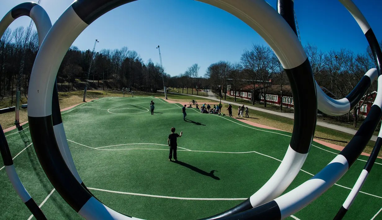 Anak-anak bermain di lapangan Puckelboll yang ada di Skarholmen, Stockholm, Swedia, 11 April 2016. Bentuk lapangan bergelombang ini didesain oleh Johan Storm dengan ukuran 25 x 40 meter. (Jonathan NACKSTRAND/AFP)
