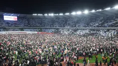 Suporter Timnas Georgia tumpah ruah turun kelapangan setelah timnya berhasil mengalahkan Yunani dalam laga playoff yang menegangkan di Tbilisi, Rabu (27/4/2024). Georgia sukses mencetak sejarah dengan lolos ke Euro 2024 untuk pertama kalinya. (AFP/Giorgi Arjevanidze)