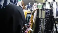 Pedagang menjualkan pakaian melalui melalui aplikasi online di Pasar Tanah Abang, Jakarta, Rabu (1/7/2020). Pedagang di Pasar Tanah Abang mulai menjual barang secara daring untuk menambah penjualan dan mengantisipasi turunnya jumlah pembeli di masa PSBB Transisi ini. (Liputan6.com/Faizal Fanani)