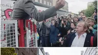 Kombinasi foto ini menunjukkan penjaga perbatasan Jerman Timur mengepalkan tangan ke beberapa demonstran, pada 7 Oktober 1989, yang melemparkan botol ke sisi Timur penghalang di titik penyeberangan Checkpoint Charlie dan lokasi yang sama pada 5 November 2019yang telah berubah. (Markus Schreiber/AP Photo)