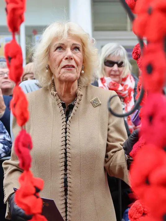 Ratu Inggris, Camilla, bereaksi saat melihat pameran bunga poppy di pusat Corsham, Inggris pada Selasa 28 Oktober 2025, sebagai bagian dari kunjungannya ke The Poppy Project. Kelompok ini menerima lebih dari 31.000 bunga poppy dari seluruh wilayah dan luar Inggris, termasuk sekolah, kelompok pemuda, rumah tinggal, dan bisnis di daerah tersebut. (Chris Jackson/POOL/AFP)