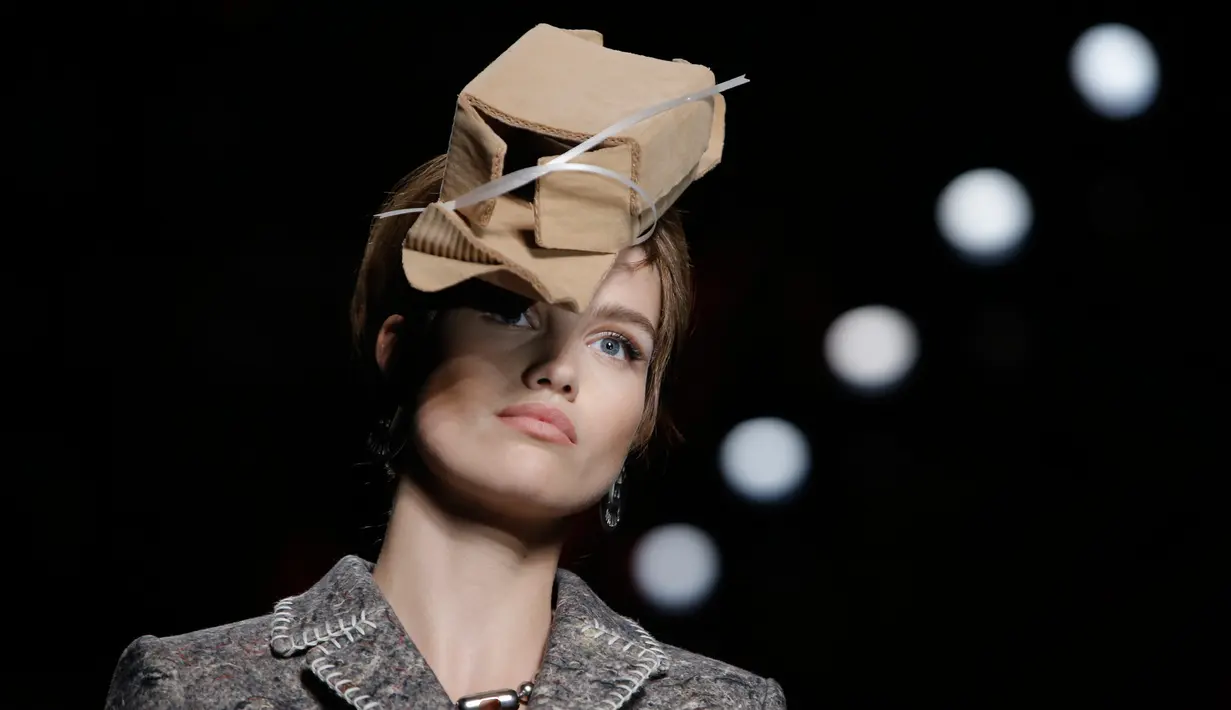 Model mengenakan busana rancangan Moschino dengan hiasan kepala berbentuk sampah kardus dalam Milan Fashion Week Autumn/Winter 2017 di Milan, Italia, (23/2). (AFP Photo / Marco Bertorello)