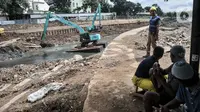 Pekerja menggunakan alat berat saat menyelesaikan proyek pembangunan sodetan Kali Ciliwung di Banjir Kanal Timur (BKT), Jakarta Timur, Senin (20/2/2023). Progres pembangunan sodetan Kali Ciliwung menuju BKT sudah mencapai 62 persen. Proyek yang menelan biaya mencapai Rp1,2 triliun ini ditargetkan berfungsi paling lambat April 2023. (merdeka.com/Iqbal S Nugroho)