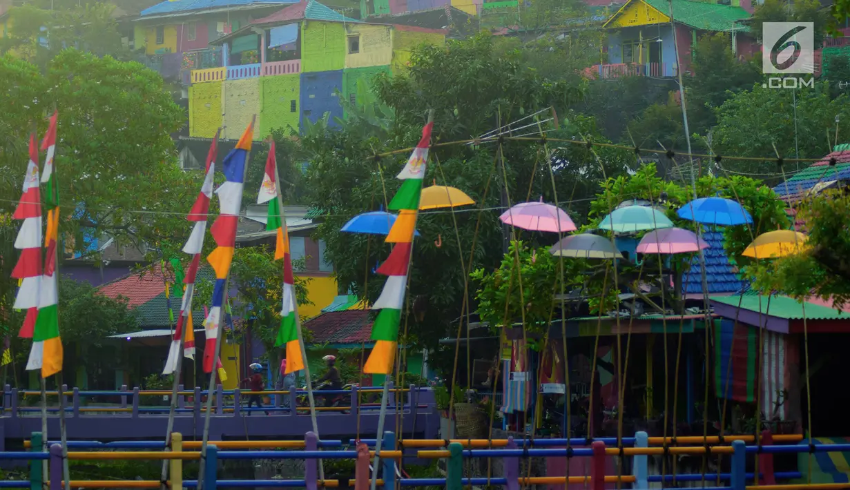 Sejumlah bendera warna-warni dan payung menghiasi Kampung Wonosari di Randusari, Semarang (24/5). Karena berada di bukit tengah kota, rumah-rumah yang dicat warna-warni tampak indah dari kejauhan. (Liputan6.com/Gholib)