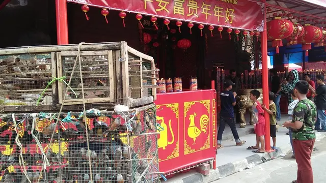 Pedagang burung pipit di depan klenteng Xian Ma Makassar (Liputan6.com/ Eka Hakim)