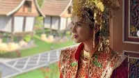 Maudy Koesnaedi memakai baju adat Minang dan suntiang di Rumah Gadang, Padang Panjang. (dok.Instagram @maudykoesnaedi/https://www.instagram.com/p/B3Y5RmzH7mx/Henry)