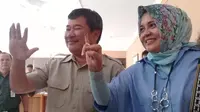 Bupati Garut Rudy Gunawan dan Istrinya Diah Kurniasari tetap mesra selepas memberikan pencoblosan di TPS jalan Kabupaten (Liputan6.com/Jayadi Supriadin)