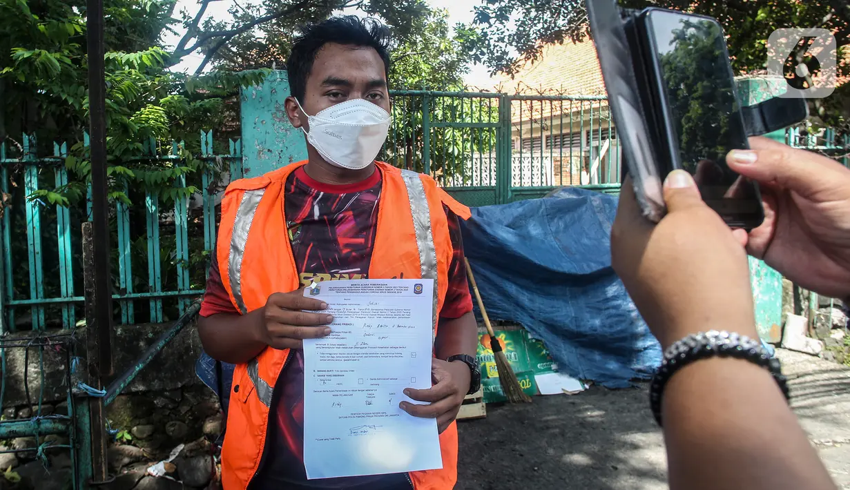 Petugas mengambil gambar warga yang terkena Razia Protokol Kesehatan di Kebayoran Lama, Jakarta, Selasa (19/10/2021). Razia PPKM Level 3 kerap dilakukan demi memutus rantai penyebaran covid-19, dengan sanksi denda Rp 100.000 dan sanksi sosial seperti menyapu jalan. (Liputan6.com/Johan Tallo)