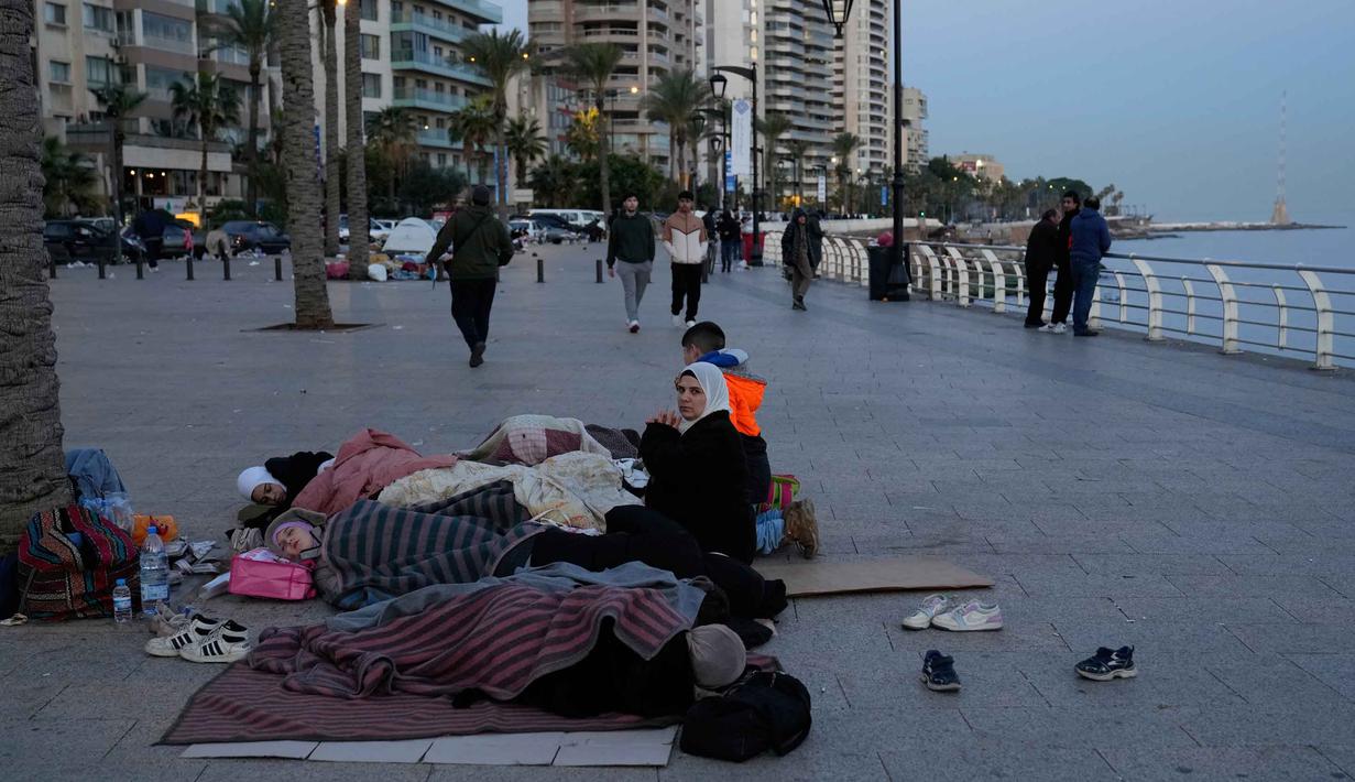 Perintah evakuasi memicu kepanikan luar biasa. Ruas jalan utama menuju pusat kota Beirut dan wilayah utara mengalami kemacetan total karena ribuan keluarga mencoba menyelamatkan diri secara bersamaan. Tampak dalam foto, para pengungsi yang melarikan diri dari serangan udara Israel di Dahiyeh, pinggiran selatan Beirut, tidur di tepi pantai Beirut, Lebanon, Jumat, 6 Maret 2026. (AP Photo/Hussein Malla)