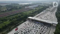 Foto udara sejumlah kendaraan pemudik saat memasuki Gerbang Tol Cikampek Utama menuju arah Tol Cipali di Karawang, Jawa Barat, Sabtu (6/4/2024). (Liputan6.com/Herman Zakharia)