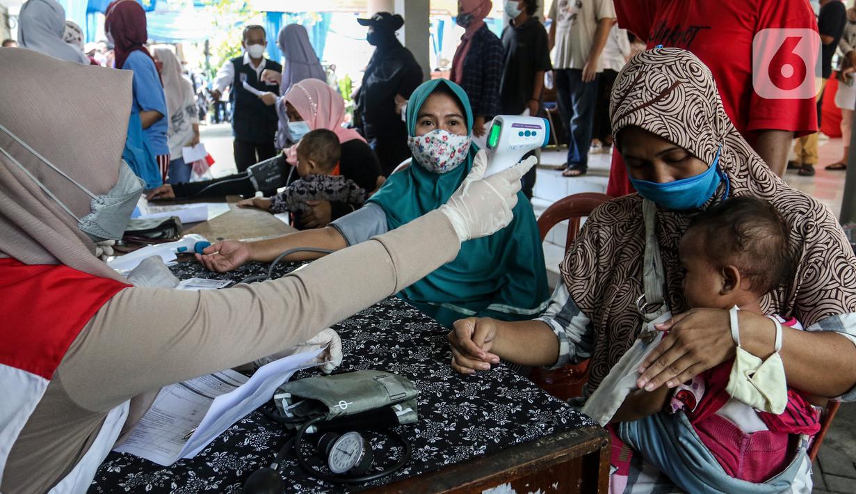 Warga saat diukur suhu tubuh sebelum menerima vaksin Pfizer dosis pertama di Kecamatan Beji, Depok,Rabu (1/9/2021). Pemerintah Kota Depok menggelar program Gebyar Vaksinasi Covid-19 secara serentak di 11 kecamatan di Kota Depok. (Liputan6.com/Johan Tallo)