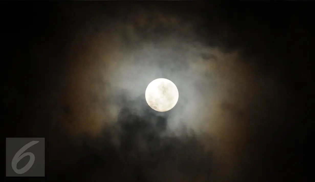 Fenomena alam Supermoon dikelilingi awan tampak di langit Kabupaten Bogor, Jawa Barat, Senin (14/11). Fenomena ini terjadi saat bulan mencapai titik terdekat dengan bumi dalam kondisi purnama atau penuh. (Liputan6.com/Helmi Fithriansyah)