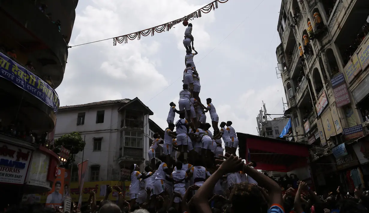 Umat Hindu membentuk piramida manusia untuk mencapai dan memecahkan dahi-handi (pot yang terbuat dari tanah liat) selama Festival Janmashtami di Mumbai, India pada 24 Agustus 2019. Festival ini menandai kelahiran dewa Krishna. (AP Photo/Rajanish Kakade)
