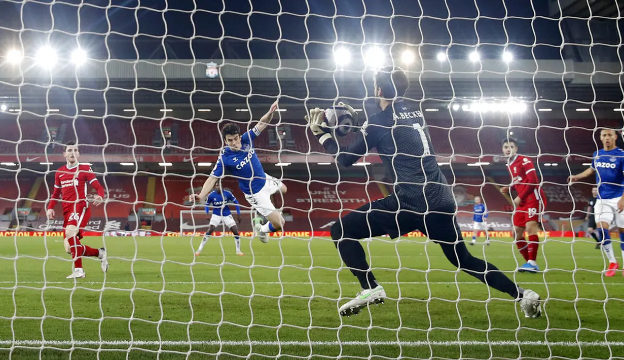 Pemain Everton Seamus Coleman melompat ke udara saat sundulannya diselamatkan oleh kiper Liverpool Alisson pada pertandingan Liga Inggris di Anfield, Liverpool, Inggris, Sabtu (20/2/2021). Liverpool kalah 0-2. (Phil Noble/Pool via AP)