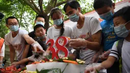 Orang-orang membuat kue ulang tahun spesial untuk panda raksasa Xinxing di Kebun Binatang Chongqing di Kota Chongqing, China pada 16 Agustus 2020. "Nenek panda" yang menjadi bintang di kebun binatang itu pada Minggu (16/8) berulang tahun ke-38, setara usia 110-150 tahun pada manusia (Xinhua/Tang Yi)