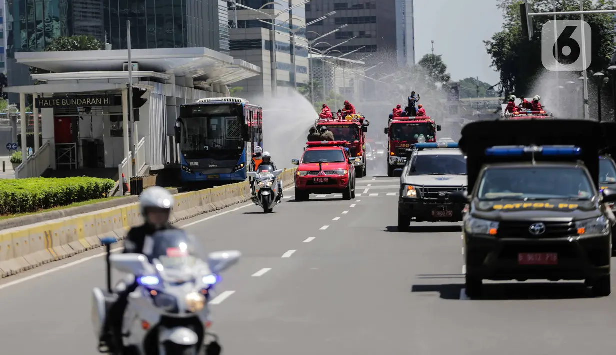 Mobil pemadam dari Dinas Pemadam Kebakaran Pemprov DKI melakukan penyemprotan cairan disinfektan di Jalan Thamrin, Jakarta, Selasa (31/3/2020). Penyemprotan yang dilakukan terus menerus itu untuk meminimalisir penyebaran COVID-19 di ruang udara dan ruas jalan. (Liputan6.com/Faizal Fanani)