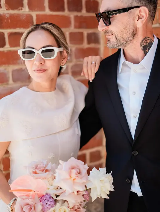 Penampilan Chantal semakin sempurna, dengan detail kitten heels berwarna putih yang serasi dan membawa buket bunga bernuansa pink yang cantik. [Foto: Instagram/chantaldellaconcetta_]