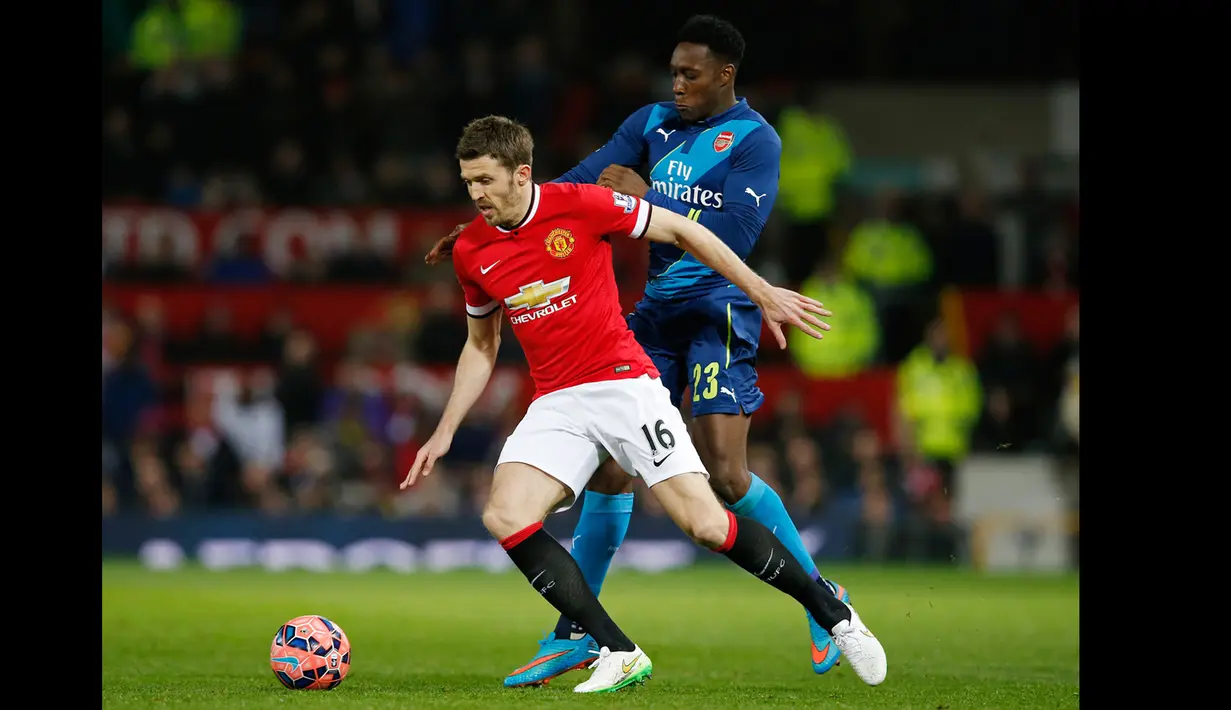 Gelandang Manchester, Michael Carrick berusaha melewati pemain depan Arsenal Danny Welbeck saat laga perempat final Piala FA di Stadion Old Trafford, Inggris (10/3/2015). Arsenal Menang 2-1 atas Manchester United. (Reuters/Andrew Yates)