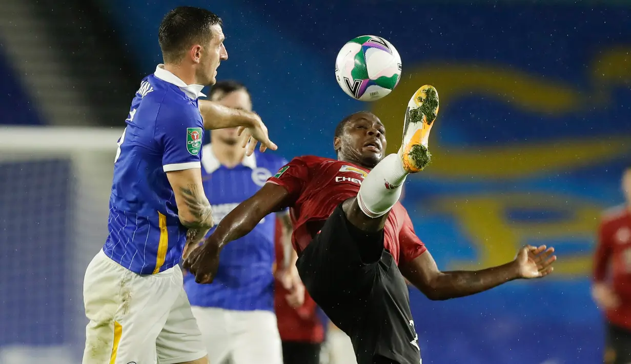 Penyerang Manchester United (MU),  Odion Ighalo menendang bola menjauh dari pemain Brighton Albion Lewis Dunk dalam lanjutan Piala Liga di Stadion Falmer, Kamis (1/10/2020) dinihari WIB. MU menang 3-0 atas Brighton Albion. (Matt Dunham/Pool via AP)