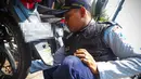 Seorang petugas mencabut pentil sebuah sepeda motor yang parkir liar di kawasan Glodok Jakarta, Selasa (9/9/2014) (Liputan6.com/Faizal Fanani)