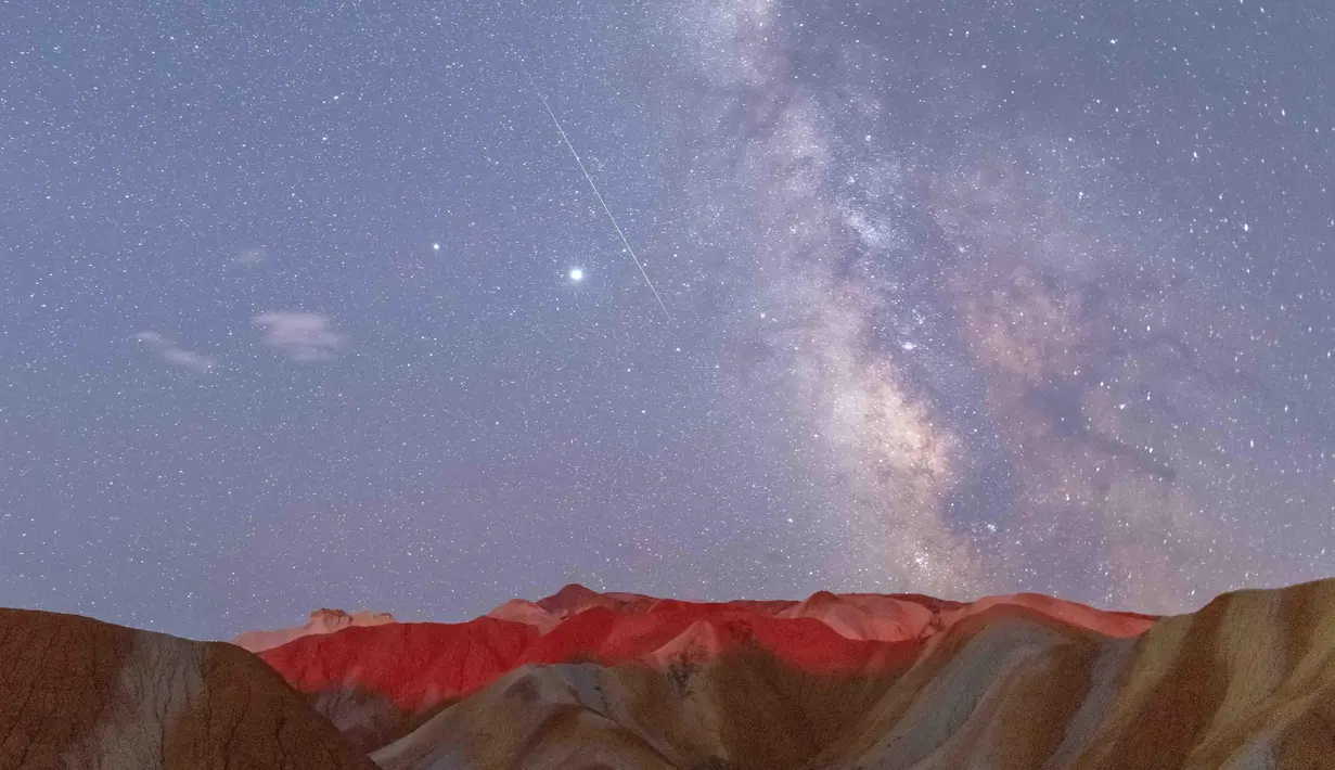 Foto eksposur panjang yang diabadikan pada 12 Agustus 2020 ini menunjukkan hujan meteor Perseid di Taman Geologi Nasional Danxia Zhangye di Zhangye, Provinsi Gansu, China barat laut. (Xinhua/Zhong Xiaoliang)