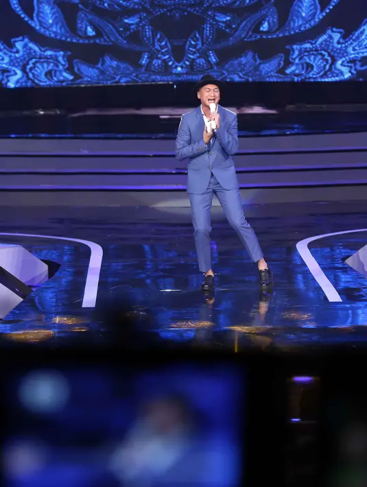 Anji, penyanyi pria bersuara emas ini berhasil mengajak para hadirin untuk turut serta bernyanyi dengannya. Bukan hanya menyanyikan satu buah lagu, namun suara Anji juga menemani finalis yang masuk di enam besar. (Nurwahyunan/Bintang.com)