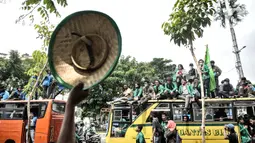 Buruh tani menyapa mahasiswa yang ikut dalam longmarch menuju Istana Negara Jalan Salemba Raya, Jakarta, Selasa (20/10/2020). Ratusan buruh dan tani dari berbagai daerah tersebut akan menggelar aksi di Istana Negara menolak UU Omnibus Law Cipta Kerja. (merdeka.com/Iqbal S. Nugroho)