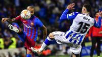 Pemain Barcelona Dani Alves (kiri) berebut bola dengan pemain Real Sociedad Diego Rico pada pertandingan Liga Spanyol di Reale Arena Stadium, San Sebastian, Spanyol, 21 April 2022. Barcelona menang 1-0. (AP Photo/Alvaro Barrientos)