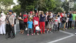 Antusias warga yang tengah mengikuti Car Free Day (CFD) menyaksikan Parade Asian Games 2018 2018 di Jalan Thamrin, Jakarta, Minggu (13/5). Parade Asian Games 2018 jadi pusat perhatian pengunjung Car Free Day. (Liputan6.com/Arya Manggala)