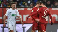 Robert Lewandowski dan Thomas Muller merayakan gol Bayern Munchen ke gawang Augsburg pada laga Bundesliga di WWK Arena, Augsburg, Minggu (14/2/2016) malam WIB. (AFP/Christoph Stache)