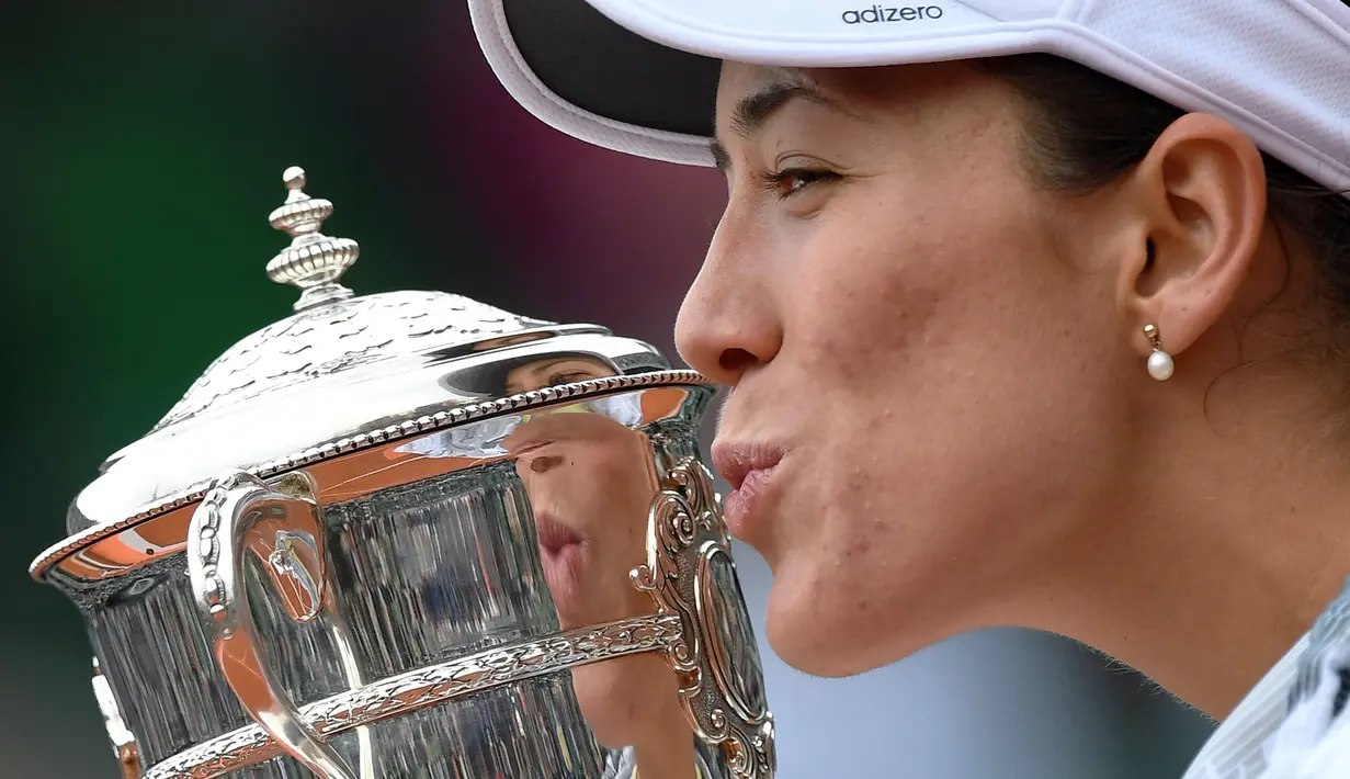 Garbine Muguruza mencium trofi usai mengalahkan Serena Williams 7-5, 6-4 pada final Roland Garros 2016 Prancis Terbuka di Paris (4/6/2016). (AFP/Miguel Medina)