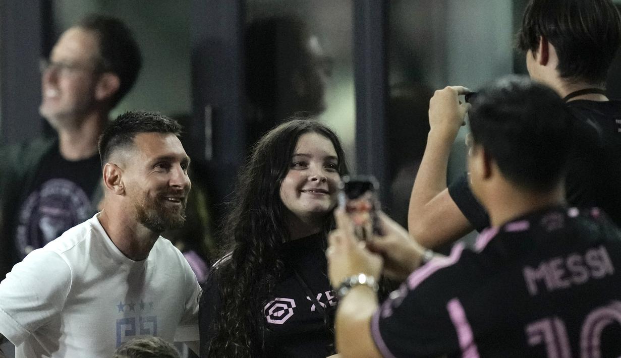 Pemain Inter Miami, Lionel Messi (kiri), berpose bersama penggemar setelah menyaksikan timnya melawan Charlotte FC pada lanjutan kompetisi Major League Soccer 2023/2024 yang berlangsung di DRV PNK Stadium, Kamis (19/10/2023). (AP Photo/Rebecca Blackwell)