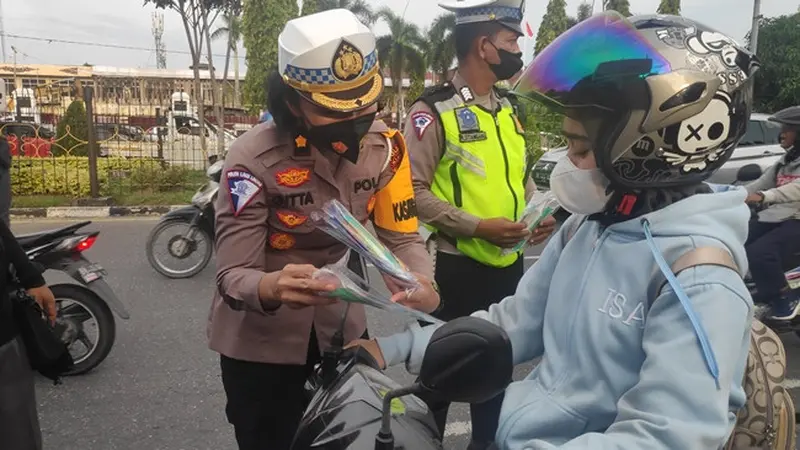 Personel Lalu Lintas Polda Riau memberikan hadia kepada pengguna jalan yang tertib pada Operasi Zebra Lancang Kuning.