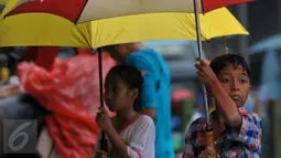 Pengojek payung saat menjajakan jasanya di kawasan Tanah Abang, Jakarta, Selasa (9/2). Tidak ada tarif khusus yang ditawarkan oleh para pengojek payung tersebut. (Liputan6.com/Faisal R Syam)