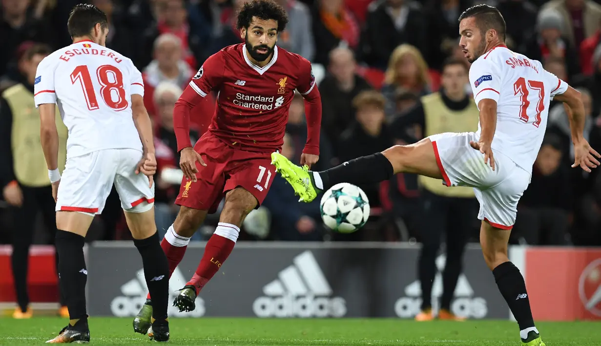 Gelandang Liverpool, Mohamed Salah berebut bola dengan pemain Sevilla, Sergio Escudero dan Pablo Sarabia dalam laga Grup E Liga Champions di Stadion Anfield, Rabu (13/9). Sevilla berhasil menahan imbang Liverpool dengan skor 2-2. (Paul ELLIS / AFP)
