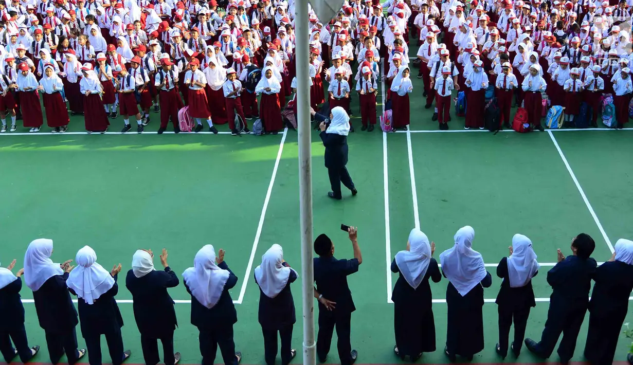 Murid-murid sekolah dasar berkumpul di halaman sekolah SDN 03, Pesanggrahan, Jakarta Selatan, Senin (16/7). Hari ini merupakan hari pertama masuk sekolah bagi para siswa dari jenjang TK hingga SMA untuk tahun ajaran 2018-2019. (Merdeka.com/Arie Basuki)