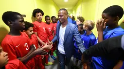Pemain Timnas Prancis, Patrice Evra, bersama para pemain muda Les Ulis sebelum bertanding, (23/5/2016). (AFP/Franck Fife) 