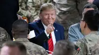 Presiden Amerika Serikat Donald Trump menunjuk sambil makan bersama para tentara di Pangkalan Udara Bagram, Afghanistan, Kamis (28/11/2019). Kunjungan dadakan Trump pada hari Thanksgiving tersebut mengejutkan pasukan AS yang bertugas di Afghanistan. (AP Photo/Alex Brandon)