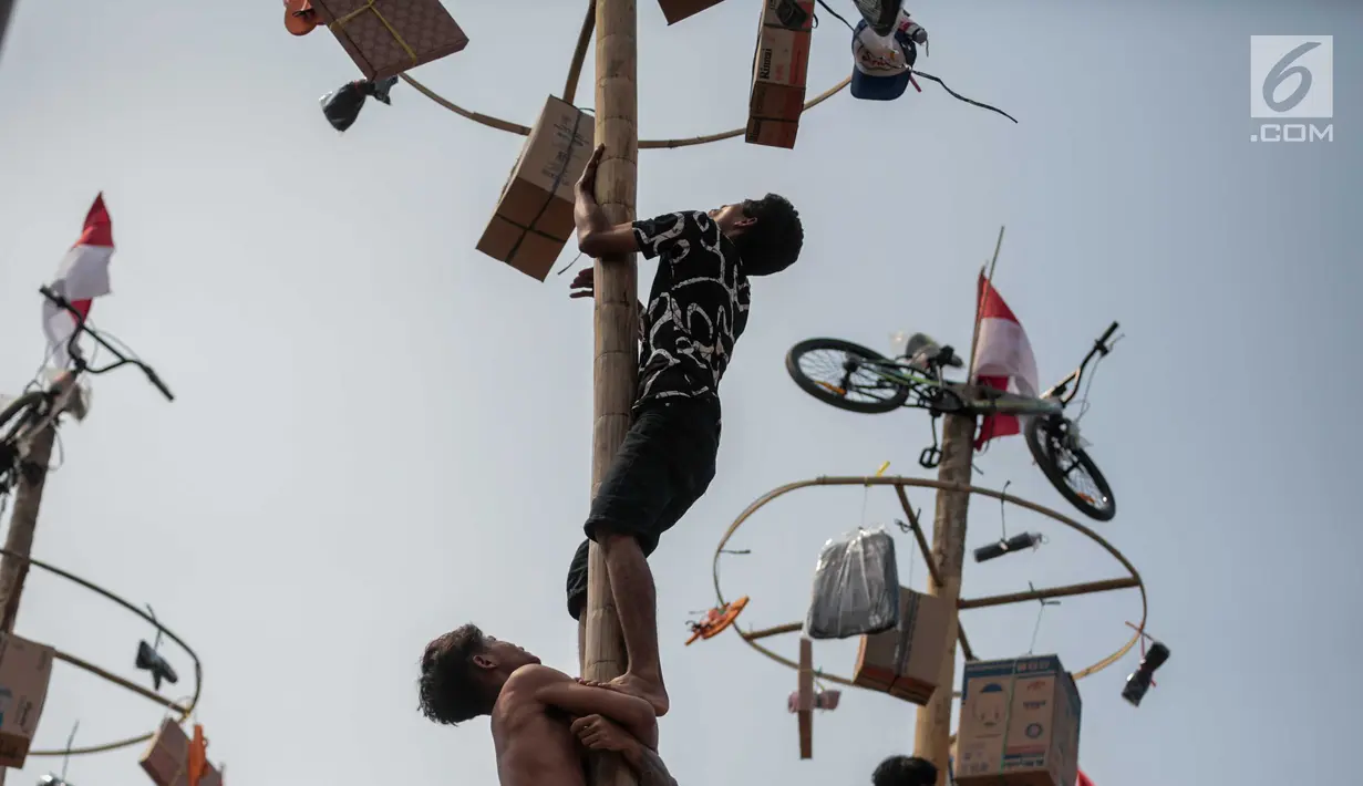Warga mengikuti lomba Panjat Pinang Kolosal dalam rangka merayakan HUT ke-74 Kemerdekaan RI di Pantai Karnaval Ancol, Jakarta, Senin (17/8/2019). Sebanyak 174 batang pinang dengan beragam hadiah disediakan dalam lomba yang diikuti ratusan warga itu. (Liputan6.com/Faizal Fanani)