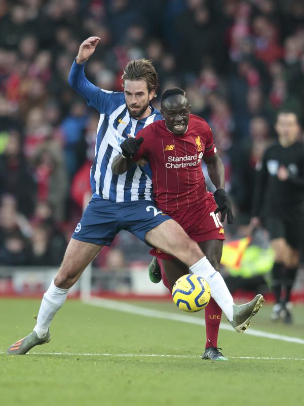 Penyerang Liverpool, Sadio Mane (kanan) berusaha melewati gelandang Brighton and Hove Albion, Davy Proepper pada pertandingan lanjutan Liga Inggris di Stadion Anfield (30/11/2019). Liverpool menang tipis atas Brighton 2-1. (AP Photo/Jon Super)