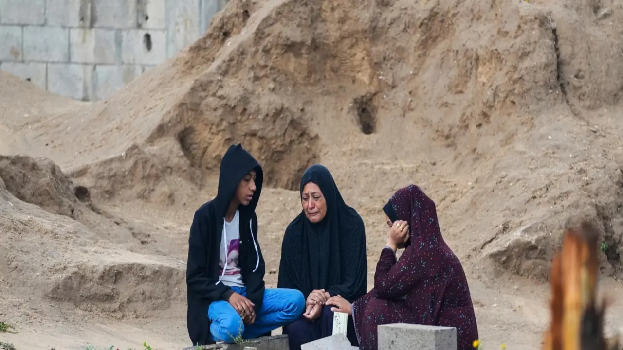 Warga Palestina mengunjungi makam kerabat mereka yang tewas dalam perang Israel vs Hamas pada hari pertama hari raya Idul Fitri, di Deir al-Balah, Gaza, 10 April 2024. (AP)