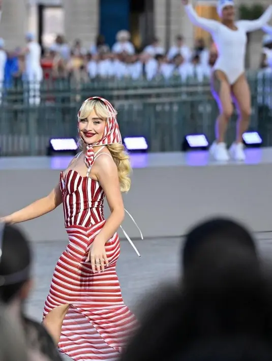 Sabrina Carpenter mengenakan baju renang bergaris merah putih dengan sarung bergaris merah putih yang serasi. [Foto: Instagram/alice.prokoptseva]