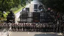 Ratusan petugas berjajar menutup Jalan Medan Merdeka Barat, Senin (1/5). Aksi perayaan Hari Buruh Internasional oleh ribuan buruh tertahan di depan Kementerian Pariwisata akibat penutupan Jalan medan Merdeka Barat. (Liputan6.com/Helmi Fithriansyah)