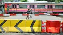 Warga mengambil gambar KRL yang melintasi perlintasan kereta api Stasiun Tebet, Jakarta, Kamis (7/4). Dishubtrans DKI melakukan uji coba penutupandan pengalihan arus lalu lintas di bawah flyover Tebet tepat depan Stasiun Tebet. (Liputan6.com/Yoppy Renato)